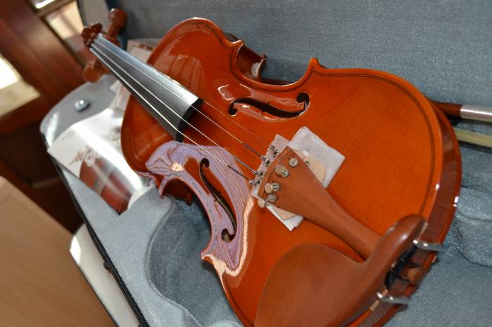 Piano, violinos, violas, bateria, violoncelo e estantes de partitura aguardam pelos músicos