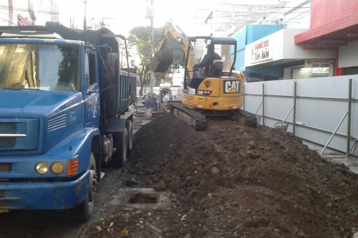 Máquinas e caçamba removem o aterro excedente