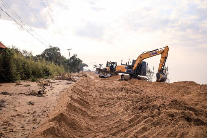 Equipes da Prefeitura fazem a desobstrução e redefinição do leito da via para instalação de ponte provisória a cargo do Exército