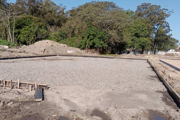 Equipes trabalham na limpeza da área, no reboco e pilares dos muros, na colocação de areia nas quadras esportivas, na execução de gradis metálicos e ferragens das fundações. Em breve, quadra será concretada