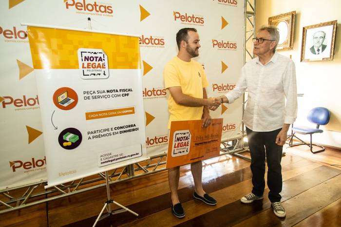 Prefeito em exercício entregou cheque de R$ 3 mil a Luís Filipe Coelho Machado, vencedor do primeiro prêmio do sorteio 11