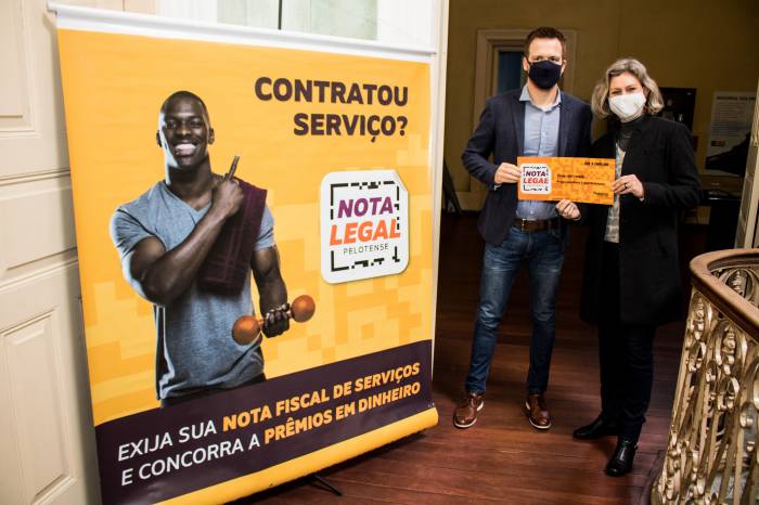 Ato simbólico registra a entrega de cheque com o valor do prêmio que receberam o primeiro colocado e a terceira ganhadora do sorteio 6